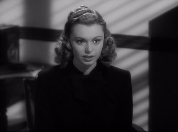 Movie still from “Double Indemnity” (1944), directed by Billy Wilder – A black and white photo of a woman in a black dress; Close Up shot, High angle