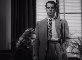 Movie still from “Double Indemnity” (1944), directed by Billy Wilder – A man and a woman standing next to each other in front of a window; Medium shot, Low angle