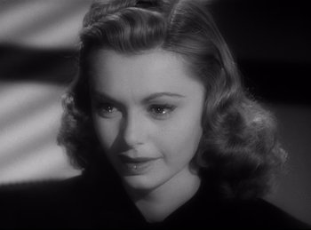 Movie still from “Double Indemnity” (1944), directed by Billy Wilder – A black and white photo of a woman in a black shirt; Close Up shot, Low angle
