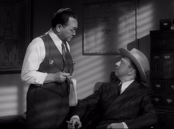 Movie still from “Double Indemnity” (1944), directed by Billy Wilder – Two men in suits and hats talking to each other; Medium shot, High angle