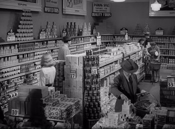 Movie still from “Double Indemnity” (1944), directed by Billy Wilder – An old photo of people in a grocery store; Wide shot, Low angle