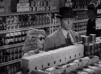 Movie still from “Double Indemnity” (1944), directed by Billy Wilder – A man and a woman are in a grocery store; Medium shot, Low angle