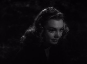 Movie still from “Double Indemnity” (1944), directed by Billy Wilder – A black and white photo of a woman in a dark room; Close Up shot, Over the shoulder angle