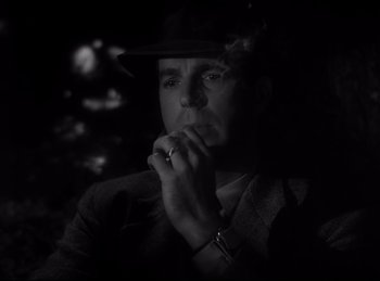 Movie still from “Double Indemnity” (1944), directed by Billy Wilder – A black and white photo of a man in a hat; Close Up shot, Low angle