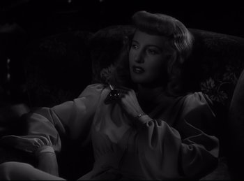 Movie still from “Double Indemnity” (1944), directed by Billy Wilder – A black - and - white photo of a woman smoking a cigarette; Close Up shot, High angle