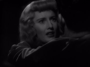 Movie still from “Double Indemnity” (1944), directed by Billy Wilder – A black and white photo of a woman in a dark room; Close Up shot, Over the shoulder angle