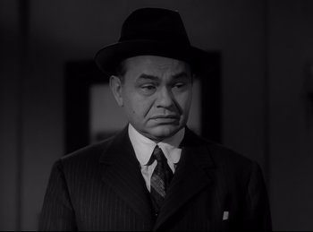 Movie still from “Double Indemnity” (1944), directed by Billy Wilder – An older man wearing a suit and a hat; Close Up shot, Low angle