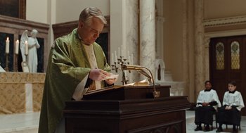 Movie still from “Doubt” (2008), directed by John Patrick Shanley – A man in a priest's outfit standing in front of a lectern; Medium shot, Low angle