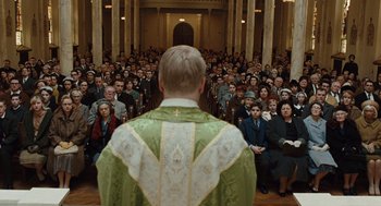 Movie still from “Doubt” (2008), directed by John Patrick Shanley – A man wearing a priest's outfit in front of a crowd; Wide shot, High angle