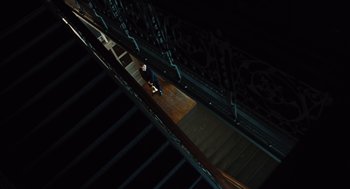 Movie still from “Doubt” (2008), directed by John Patrick Shanley – A person riding a skate board on top of a wooden floor; Extreme Wide shot, Overhead angle