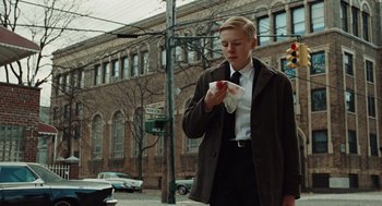 Movie still from “Doubt” (2008), directed by John Patrick Shanley – A man in a suit and tie holding a napkin; Medium shot, Low angle