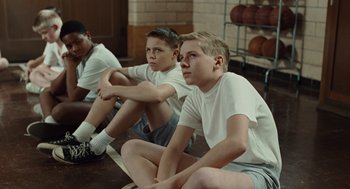 Movie still from “Doubt” (2008), directed by John Patrick Shanley – A group of young men sitting on the ground; Medium shot, High angle