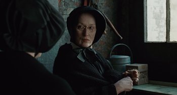 Movie still from “Doubt” (2008), directed by John Patrick Shanley – An older woman sitting in front of a man; Close Up shot, Over the shoulder angle