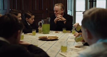 Movie still from “Doubt” (2008), directed by John Patrick Shanley – A group of people sitting at a table with drinks; Medium shot, Over the shoulder angle