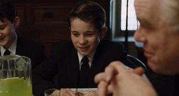 Movie still from “Doubt” (2008), directed by John Patrick Shanley – A boy in a suit and tie sitting at a dinner table; Close Up shot, Over the shoulder angle