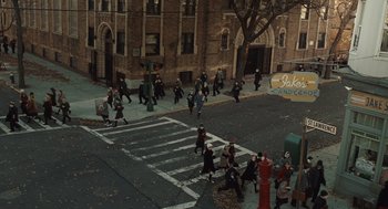 Movie still from “Doubt” (2008), directed by John Patrick Shanley – A group of people walking across a crosswalk in front of a building; Extreme Wide shot, High angle