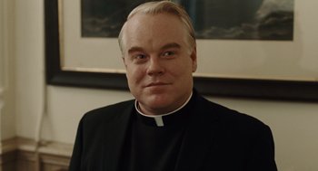 Movie still from “Doubt” (2008), directed by John Patrick Shanley – A man wearing a priest's outfit and a white collar; Close Up shot, Over the shoulder angle
