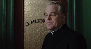 Movie still from “Doubt” (2008), directed by John Patrick Shanley – A man in a priest's outfit standing in front of a mirror; Close Up shot, Over the shoulder angle
