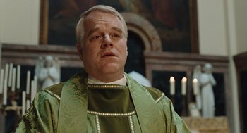 Movie still from “Doubt” (2008), directed by John Patrick Shanley – A man wearing a green robe and a green stole; Close Up shot, Low angle