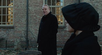 Movie still from “Doubt” (2008), directed by John Patrick Shanley – A man and a woman standing in front of a brick building; Medium shot, Over the shoulder angle