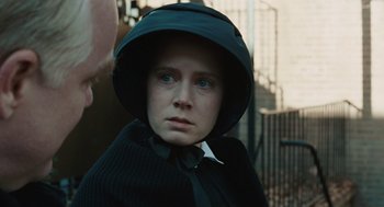 Movie still from “Doubt” (2008), directed by John Patrick Shanley – A woman wearing a black hat and a black cape; Close Up shot, Over the shoulder angle