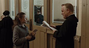 Movie still from “Doubt” (2008), directed by John Patrick Shanley – A man and a woman are standing in front of a door; Medium shot, Over the shoulder angle