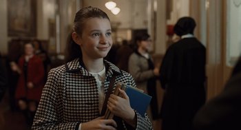 Movie still from “Doubt” (2008), directed by John Patrick Shanley – A young girl is holding a book in her hand; Medium shot, Over the shoulder angle