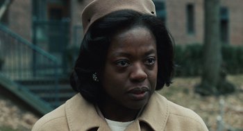 Movie still from “Doubt” (2008), directed by John Patrick Shanley – A black woman wearing a tan coat and a hat; Close Up shot, Low angle