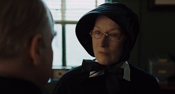 Movie still from “Doubt” (2008), directed by John Patrick Shanley – An older woman wearing a black outfit and a hat; Close Up shot, Over the shoulder angle