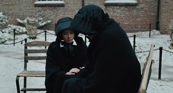 Movie still from “Doubt” (2008), directed by John Patrick Shanley – Two people sitting next to each other on steps; Medium shot, High angle