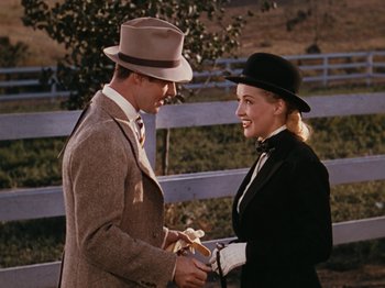 Movie still from “Down Argentine Way” (1940), directed by Irving Cummings – A man and a woman in a suit and hat; Medium shot, Over the shoulder angle