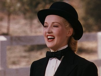 Movie still from “Down Argentine Way” (1940), directed by Irving Cummings – A woman wearing a black suit and a black hat; Close Up shot, Low angle
