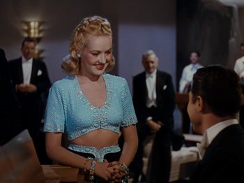 Movie still from “Down Argentine Way” (1940), directed by Irving Cummings – A woman in a blue top talking to a man in a black suit; Medium shot, Over the shoulder angle