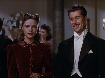 Movie still from “Down Argentine Way” (1940), directed by Irving Cummings – A man and a woman standing next to each other in formal wear; Medium shot, Low angle