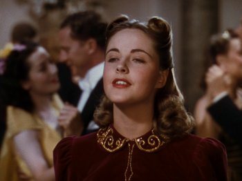 Movie still from “Down Argentine Way” (1940), directed by Irving Cummings – A woman in a red dress and a gold necklace; Close Up shot, Low angle
