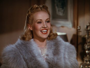 Movie still from “Down Argentine Way” (1940), directed by Irving Cummings – A woman with blonde hair wearing a fur coat; Close Up shot, Over the shoulder angle