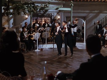 Movie still from “Down Argentine Way” (1940), directed by Irving Cummings – A group of men in suits and ties performing a dance; Extreme Wide shot, High angle