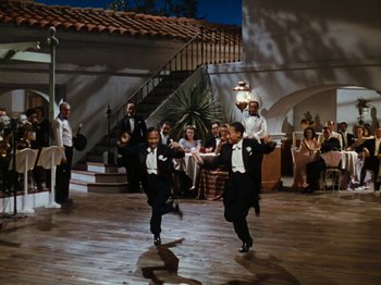 Movie still from “Down Argentine Way” (1940), directed by Irving Cummings – A group of men in tuxedos dancing in front of an audience; Wide shot, High angle