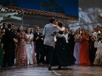 Movie still from “Down Argentine Way” (1940), directed by Irving Cummings – A group of people standing in a room with a crowd; Wide shot, High angle