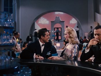 Movie still from “Down Argentine Way” (1940), directed by Irving Cummings – A man and a woman sitting at a bar talking to each other; Medium shot, Over the shoulder angle