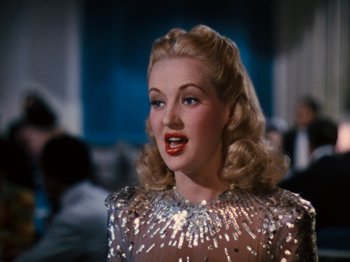 Movie still from “Down Argentine Way” (1940), directed by Irving Cummings – A woman with blonde hair wearing a silver dress; Close Up shot, Low angle