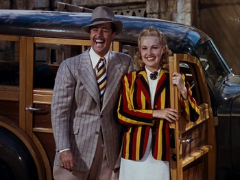 Movie still from “Down Argentine Way” (1940), directed by Irving Cummings – A man and a woman standing in front of an old car; Medium shot, Low angle