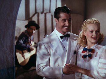 Movie still from “Down Argentine Way” (1940), directed by Irving Cummings – A man and a woman in a white suit and bow tie; Medium shot, Low angle