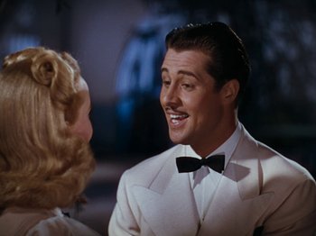 Movie still from “Down Argentine Way” (1940), directed by Irving Cummings – A man in a white suit talking to a woman in a white dress; Close Up shot, Low angle