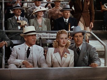 Movie still from “Down Argentine Way” (1940), directed by Irving Cummings – A group of men and women sitting next to each other; Medium shot, High angle