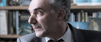 Movie still from “Down Terrace” (2009), directed by Ben Wheatley – An older man in a suit and tie looking to his left; Close Up shot, Over the shoulder angle