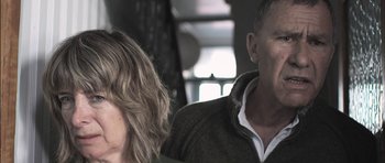 Movie still from “Down Terrace” (2009), directed by Ben Wheatley – A man and a woman sitting next to each other; Close Up shot, Low angle