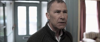 Movie still from “Down Terrace” (2009), directed by Ben Wheatley – An older man in a brown sweater looking at the camera; Close Up shot, Low angle