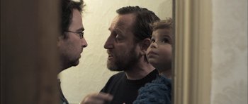 Movie still from “Down Terrace” (2009), directed by Ben Wheatley – A man and a child looking at each other in a mirror; Close Up shot, Over the shoulder angle