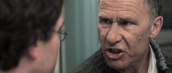 Movie still from “Down Terrace” (2009), directed by Ben Wheatley – An older man with glasses talking to a younger woman; Close Up shot, Over the shoulder angle
